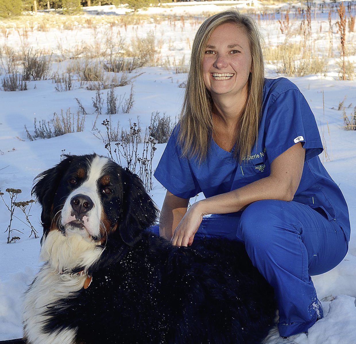 Dr. Carrie Nedele with a dog in the snow